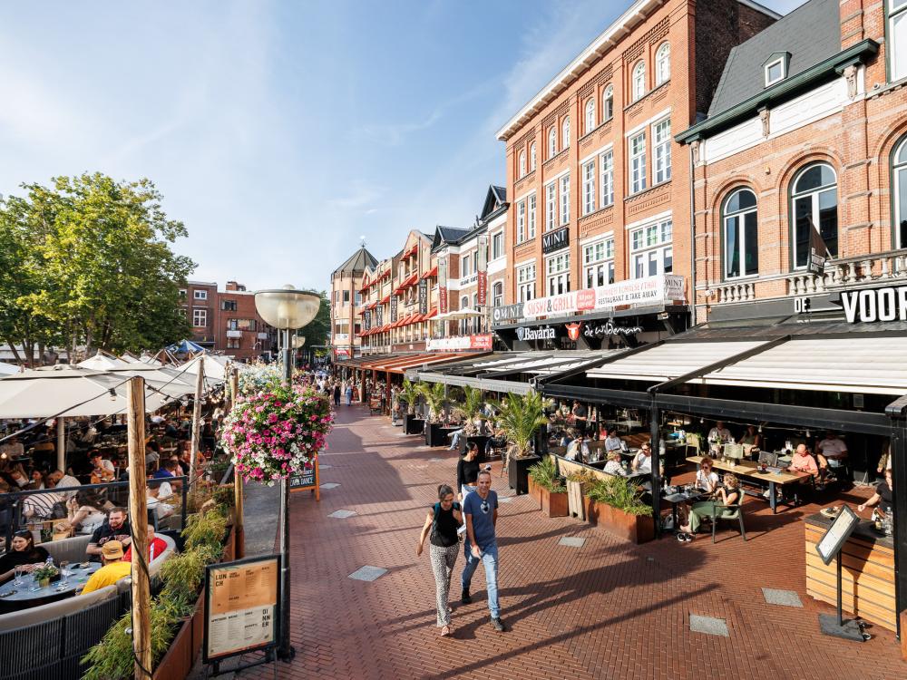 Een foto van de Markt met volle terrassen.