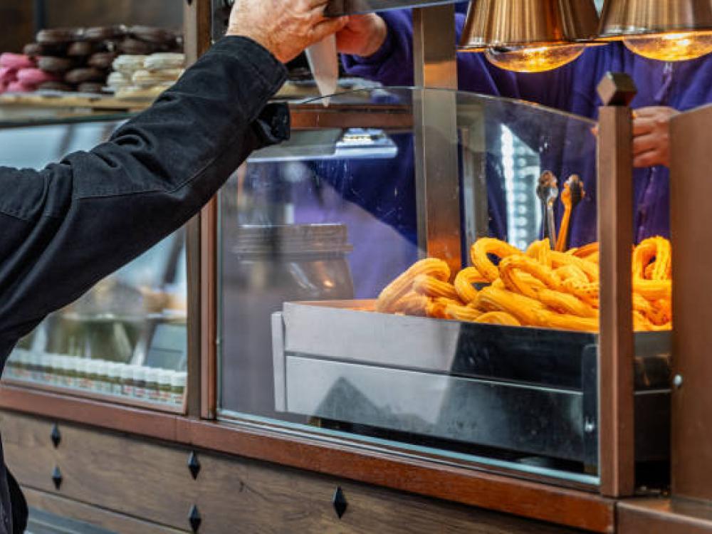 Klant haalt een bestelling af bij een eetkraampje