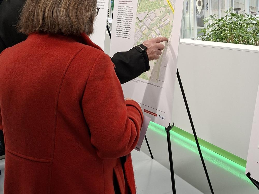 Op deze foto staan mensen die het ontwerp aan het bekijken zijn.